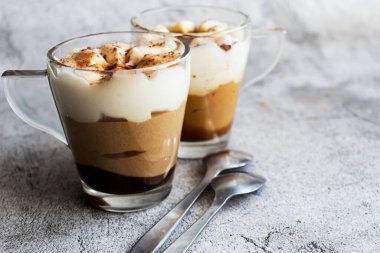 Kahve tatlısı. Gri bir arkaplanda. Tiramisu fincanda.