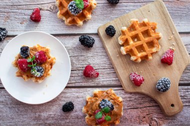 Böğürtlenli waffle. Meyveli Belçika waffle 'ı. - Günaydın. Ahşap bir arka planda