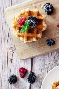 Böğürtlenli waffle. Meyveli Belçika waffle 'ı. - Günaydın. Ahşap bir arka planda