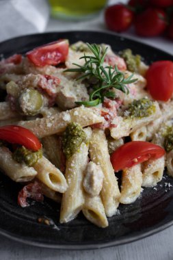 Peynirli makarna ve pesto. Beyaz ahşap bir arka planda. Lezzetli bir yemek.