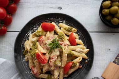 Peynirli makarna ve pesto. Beyaz ahşap bir arka planda. Lezzetli bir yemek.