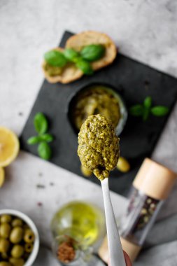 Lezzetli pesto sosu beyaz kasede mermer masada, düz yerde.