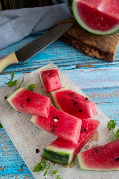 Watermelon slices in a glass on a wooden background. Slices of watermelon on a wooden board.