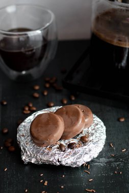 Çikolata kaplı cam bardakta kahve. Siyah bir arkaplanda.