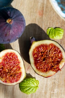 Kesme tahtasındaki taze incirler. Mavi arka planda, ahşap. sağlıklı yiyecekler