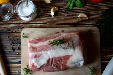 Ham domuz filetosu ve baharatlı otlar. ahşap arkaplanda.