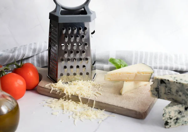 Cheese still life with grater and grater. on a white background. italian food