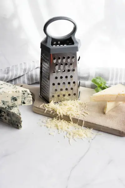 Cheese still life with grater and grater. on a white background. italian food