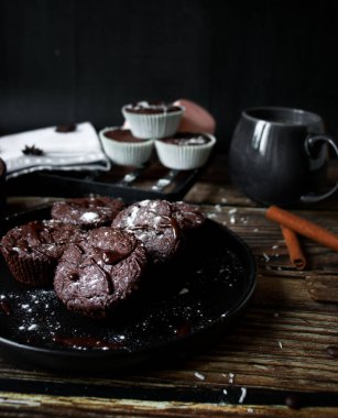 Çikolatalı kekler ve ahşap arka planda fındıklar.