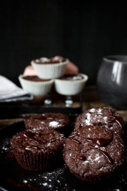 Ev yapımı çikolatalı kekler, siyah arka planı olan ahşap bir masada. seçici odak