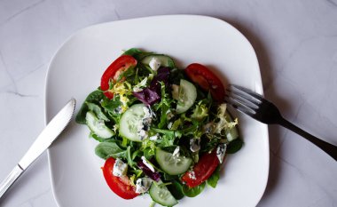 Beyaz arka planda taze sebzeli salata. Üst görünüm, boşluk kopyala