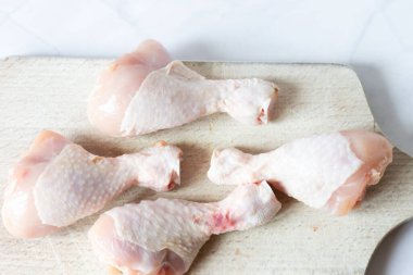 Çiğ tavuk budu, baharat ve bitkilerle. Beyaz bir arka planda. yiyecek