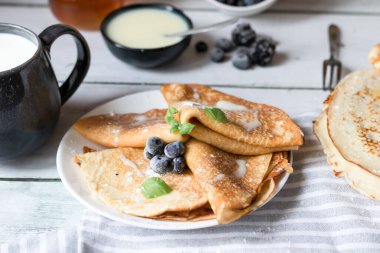 Kahvaltı: taze böğürtlenli krep. Ahşap bir arka planda. Günaydın.
