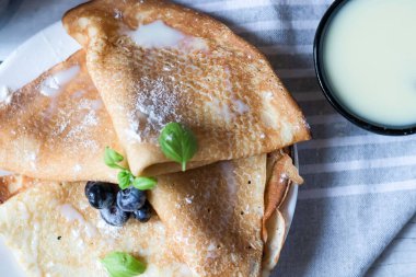Kahvaltı: taze böğürtlenli krep. Ahşap bir arka planda. Günaydın.