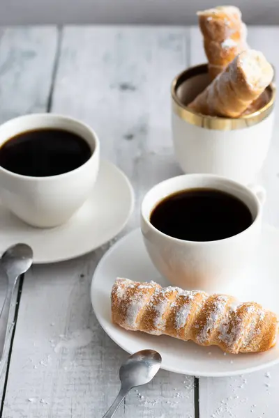 tubes with cream and coffee. on a wooden background. dessert