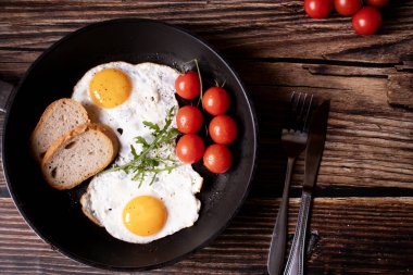 Tavada kızarmış yumurta. Tahta bir arka planda. Kahvaltı.