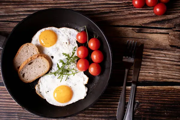 Tavada kızarmış yumurta. Tahta bir arka planda. Kahvaltı.