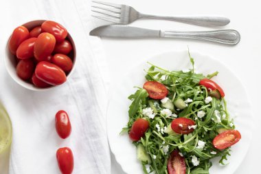 Yeşil vejetaryen salatası, roka yaprakları ve kiraz domatesleri. Atıştırmalık, yemek