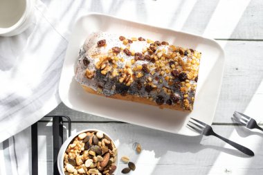 Ahşap bir arka planda haşhaş tohumlarıyla yuvarlan. tatlı 