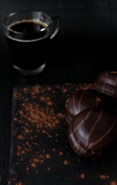Çikolata şekerleri ve siyah arka planda kahve.