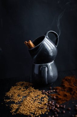 Kahve çekirdekleri, bir kaşık ve koyu arka planda bir fincan kahve. Güzel manzara. Günaydın, kahve. Siyah bir arka planda. Farklı kahve türleri.