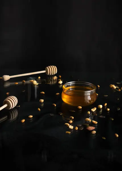 composition with bottle of honey and honeycomb on dark background