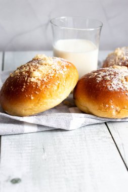 Sütlü taze çörekler. Tahta bir arka planda. akşam yemeği