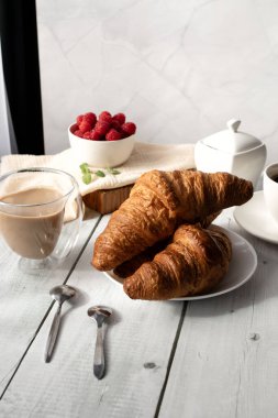 Kahve, kruvasan ve böğürtlen. Beyaz ahşap üzerinde. Kahvaltı. Günaydın..
