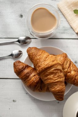 Kahve, kruvasan ve böğürtlen. Beyaz ahşap üzerinde. Kahvaltı. Günaydın..