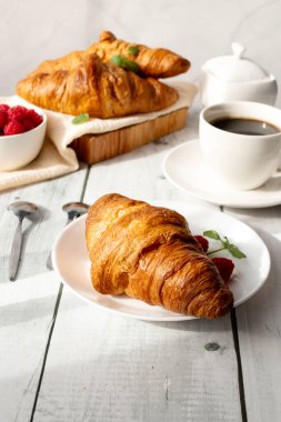 Kahve, kruvasan ve böğürtlen. Beyaz ahşap üzerinde. Kahvaltı. Günaydın..