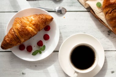 Kahve, kruvasan ve böğürtlen. Beyaz ahşap üzerinde. Kahvaltı. Günaydın..