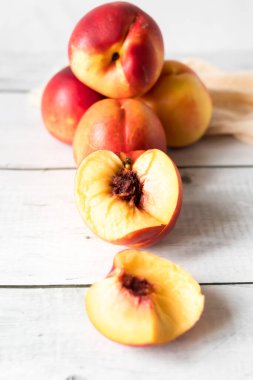 Beyaz ahşap masada olgun şeftaliler