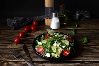 Taze salata, roka, vişneli domates ve peynir. Tahta bir arka planda. sağlıklı yiyecekler