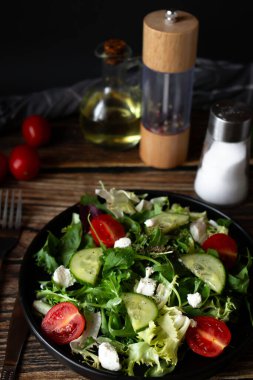 Taze salata, roka, vişneli domates ve peynir. Tahta bir arka planda. sağlıklı yiyecekler