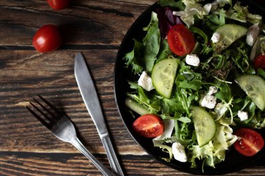 Taze salata, roka, vişneli domates ve peynir. Tahta bir arka planda. sağlıklı yiyecekler