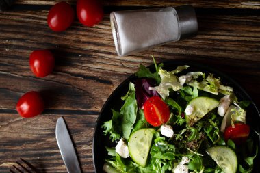 Taze salata, roka, vişneli domates ve peynir. Tahta bir arka planda. sağlıklı yiyecekler