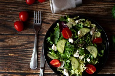 Taze salata, roka, vişneli domates ve peynir. Tahta bir arka planda. sağlıklı yiyecekler