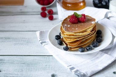 Tabağında taze böğürtlen olan krepler.