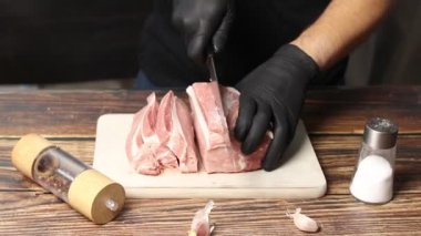 Çiğ domuz eti mutfak tahtasında dilimlenir.