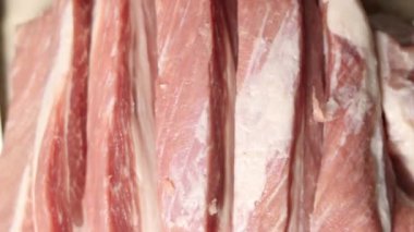 Çiğ domuz eti mutfak tahtasında dilimlenir.