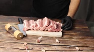 Çiğ domuz eti mutfak tahtasında dilimlenir.