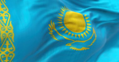 Kazakistan ulusal bayrağının dalgalanmasına yakından bakın. Kazakistan Cumhuriyeti, Asya ve Avrupa 'ya yayılmış kıtalararası bir devlettir. Kumaş desenli arka plan. Seçici odak