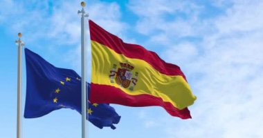 İspanya ve Avrupa Birliği 'nin bayrakları güneşli bir günde rüzgarda sallanıyor. Demokrasi ve politika. Avrupa ülkesi. Yavaş çekimde kusursuz döngü