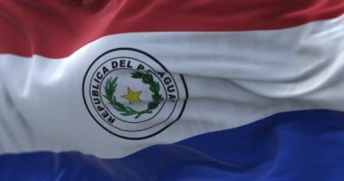 Rüzgarda dalgalanan Paraguay ulusal bayrağının yakın çekim görüntüsü. Paraguay Cumhuriyeti bir Güney Amerika devletidir. Kumaş desenli arka plan. Seçici odaklanma. Yavaş çekimde kusursuz döngü