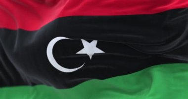 Libya Ulusal Bayrağının dalgalanmasına yakından bakın. Libya Devleti bir Kuzey Afrika devletidir. Kumaş desenli arka plan. Seçici odaklanma. Yavaş çekimde kusursuz döngü