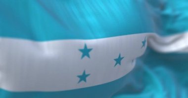 Rüzgarda dalgalanan Honduras ulusal bayrağının yakın çekim görüntüsü. Honduras Cumhuriyeti bir Orta Amerika devletidir. Kumaş desenli arka plan. Seçici odaklanma. Yavaş çekimde kusursuz döngü