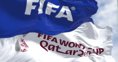 Doha, QA, Kasım 2022: FIFA ve Katar 2022 Dünya Kupası logolu bayraklar rüzgarda sallanıyor. Etkinliğin 21 Kasım - 18 Aralık 2022 tarihleri arasında Katar 'da gerçekleşmesi planlanıyor. Yavaş çekimde kusursuz döngü. 3 Boyutlu Hazırlama
