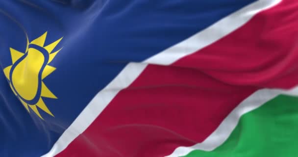 ナミビア国旗が手を振っている様子を間近で見ることができる ナミビア共和国は南アフリカの国です 生地の質感の背景 選択的フォーカス スローモーションでシームレスなループ 3Dレンダリング — ストック動画