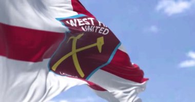 Londra, İngiltere, Ekim 2022: West Ham United F.C. bayrağı El sallıyorum. West Ham, Londra merkezli bir İngiliz futbol kulübüdür. Kumaş desenli arka plan. Seçici odaklanma. Yavaş çekimde kusursuz döngü. 3 Boyutlu Hazırlama