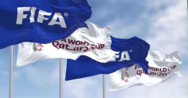 Doha, QA, Kasım 2022: FIFA ve Katar 2022 Dünya Kupası logolu bayraklar rüzgarda sallanıyor. Seçici odaklanma. Ağır çekimde sonsuz döngü. 3 Boyutlu Hazırlama